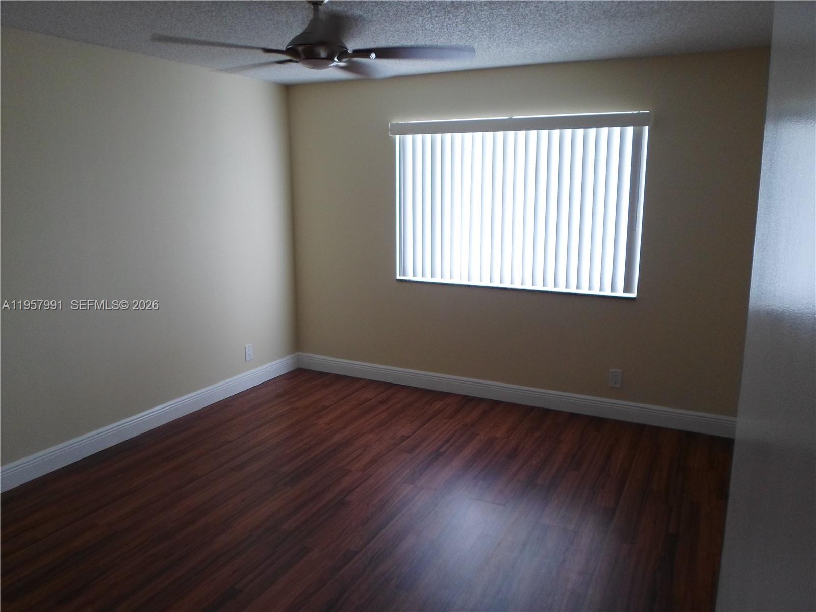 4055 West McNab Road, Unit H311 Pompano Beach, FL 33069 - Photo 6 of 14 an empty room with wooden floor and windows