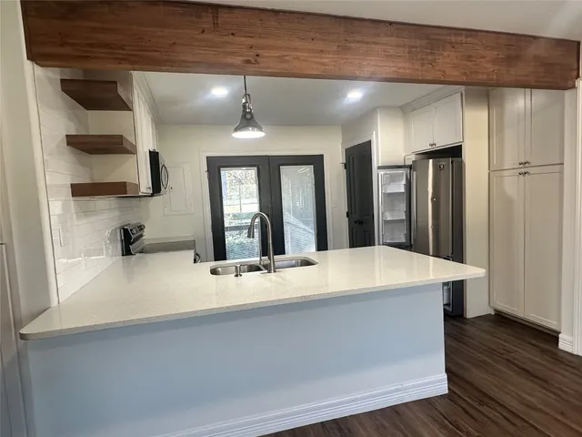 a large kitchen with stainless steel appliances a large counter top