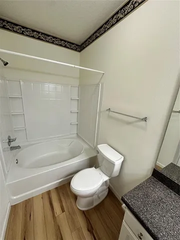 a bathroom with a granite countertop bathtub and toilet