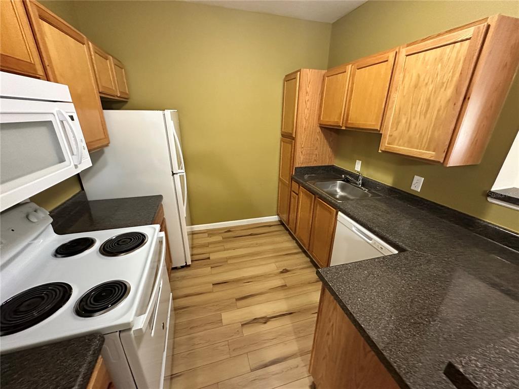 4802 51st Street West, Unit 413 Bradenton, FL 34210 - Photo 8 of 40 a kitchen with a sink and a stove top oven