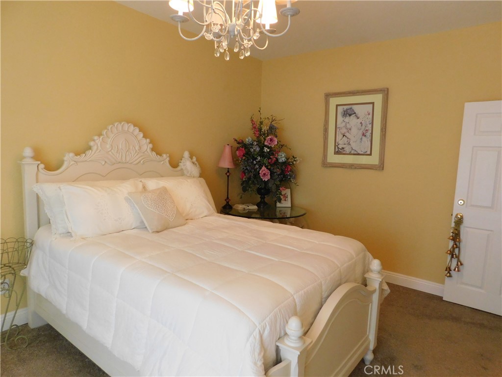 8934 Japatul Road Apple Valley, CA 92308 - Photo 12 of 16 a bedroom with a bed and a chandelier