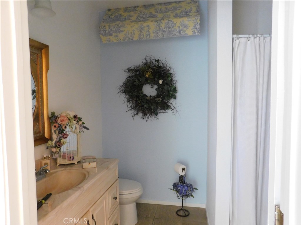 8934 Japatul Road Apple Valley, CA 92308 - Photo 13 of 16 a bathroom with a granite countertop sink a toilet and a mirror