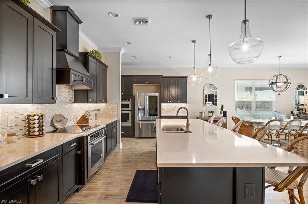 3521 Pilot Circle Naples, FL 34120 - Photo 2 of 36 a large kitchen with stainless steel appliances kitchen island granite countertop a sink a stove and a refrigerator
