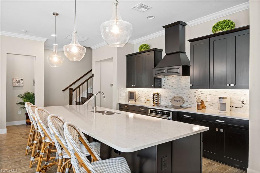 3521 Pilot Circle Naples, FL 34120 - Photo 4 of 36 a kitchen with kitchen island granite countertop a sink a center island and cabinets