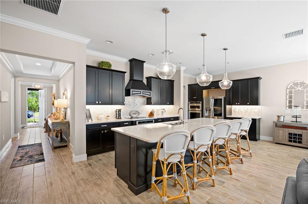 3521 Pilot Circle Naples, FL 34120 - Photo 5 of 36 a view of a dining room and livingroom with furniture wooden floor a chandelier