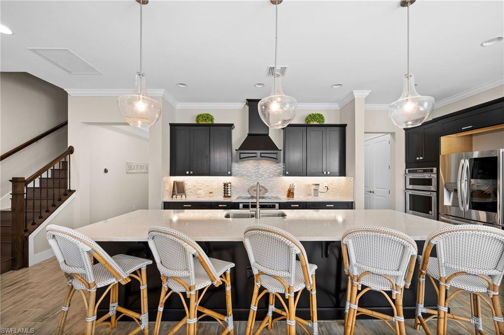 3521 Pilot Circle Naples, FL 34120 - Photo 6 of 36 a kitchen with stainless steel appliances kitchen island granite countertop a stove a sink and a chandelier