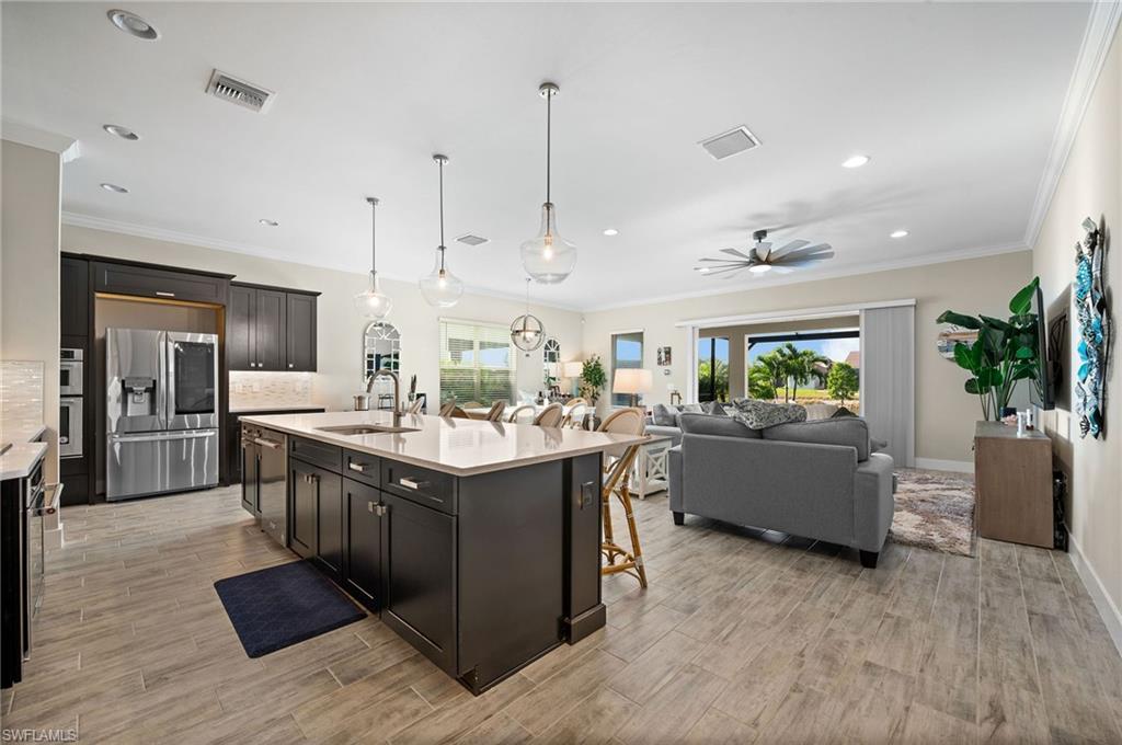 3521 Pilot Circle Naples, FL 34120 - Photo 9 of 36 a large kitchen with stainless steel appliances granite countertop a lot of counter space and wooden floor