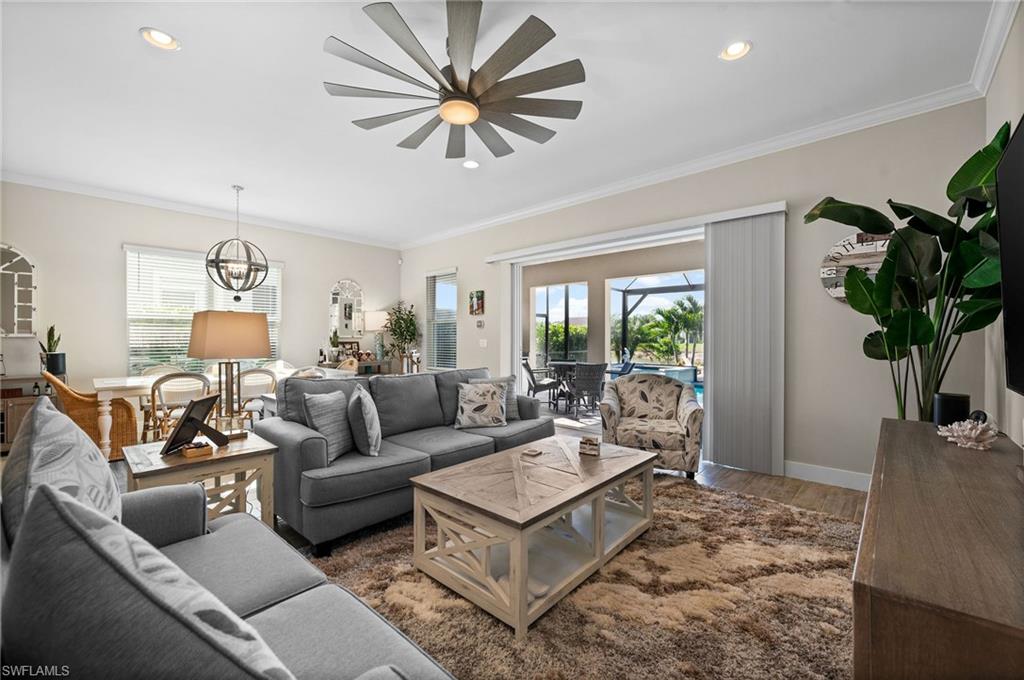 3521 Pilot Circle Naples, FL 34120 - Photo 10 of 36 a living room with furniture a chandelier and a rug