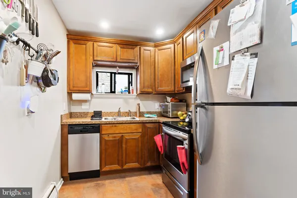 a kitchen with stainless steel appliances granite countertop a sink and a refrigerator