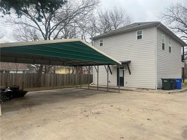a backyard of a house with barbeque oven table and chairs