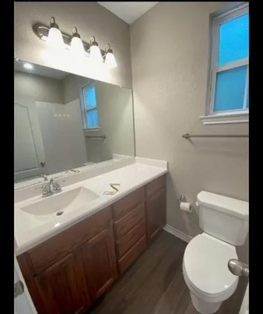 a bathroom with a toilet sink and mirror