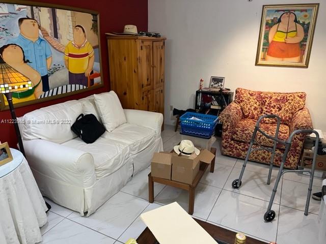 7505 Southwest 82nd Street, Unit 322 Miami, FL 33143 - Photo 5 of 10 a bedroom with a bed a couch and a painting on the wall