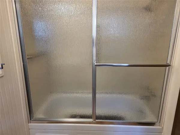 a bathroom with a glass shower door
