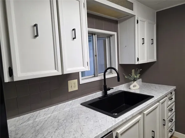 a kitchen with a sink stove and cabinets