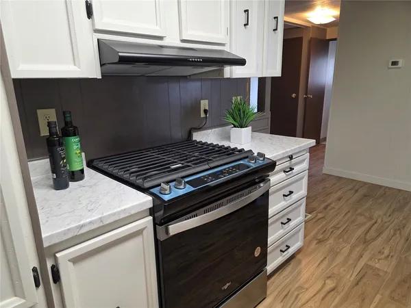 a kitchen with granite countertop a stove and a refrigerator