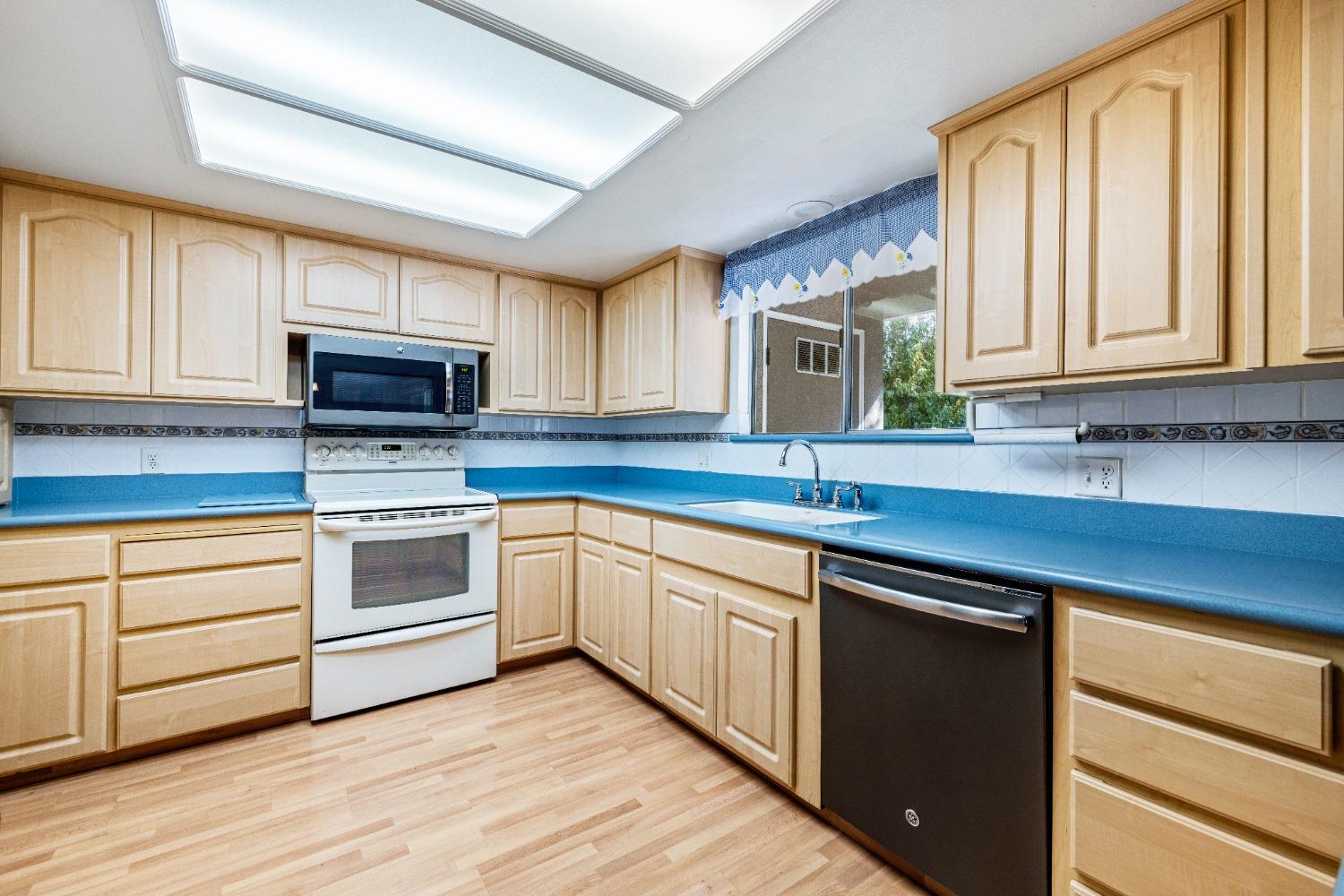 100 Hilton Street Madera, CA 93637 - Photo 20 of 30 a kitchen with granite countertop a sink cabinets stainless steel appliances and a window
