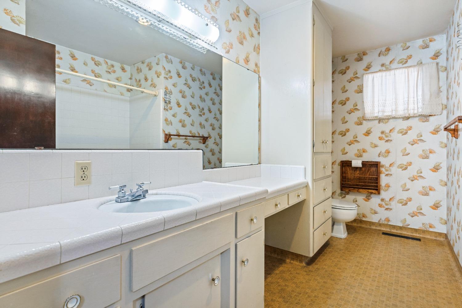 100 Hilton Street Madera, CA 93637 - Photo 9 of 30 a bathroom with a sink a toilet and a mirror