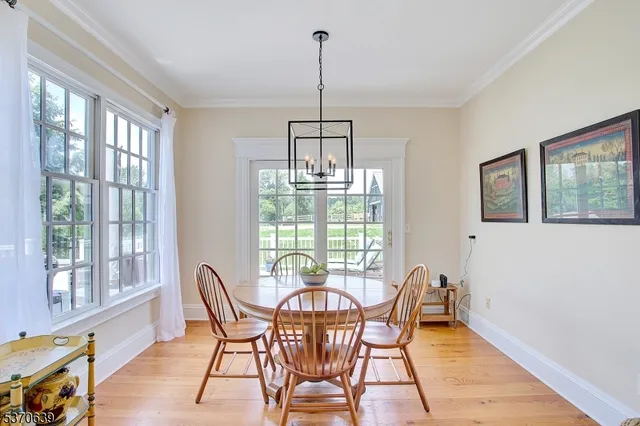 a dining room with furniture a chandelier and wooden floor