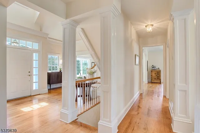a view of a hallway with wooden floor and windows