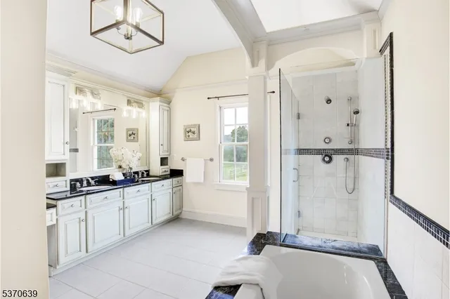 a large bathroom with a tub sink and mirror