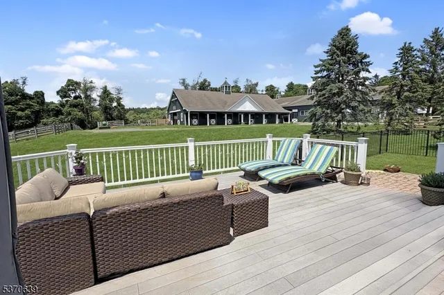 a view of a deck with couches chairs and wooden floor