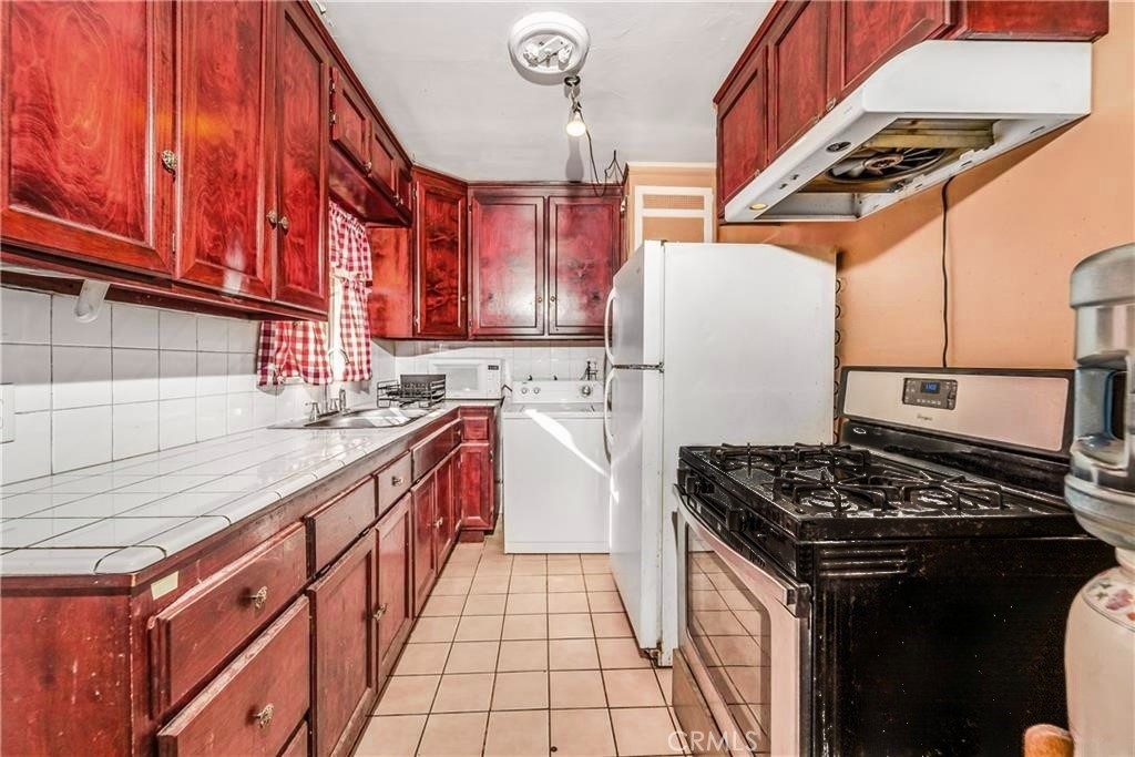1709 Rialto Avenue Colton, CA 92324 - Photo 12 of 26 a kitchen with stainless steel appliances granite countertop a stove a sink dishwasher and a refrigerator