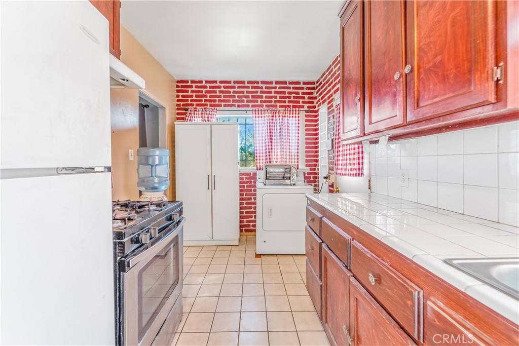 1709 Rialto Avenue Colton, CA 92324 - Photo 13 of 26 a kitchen with stainless steel appliances a refrigerator and a sink