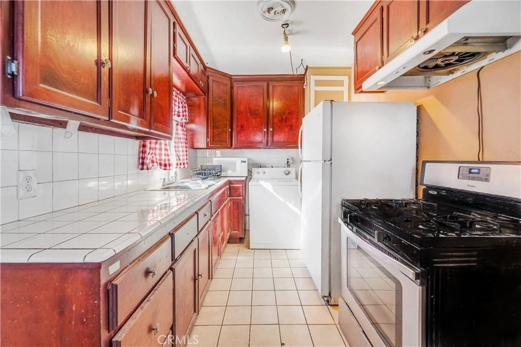 1709 Rialto Avenue Colton, CA 92324 - Photo 14 of 26 a kitchen with stainless steel appliances granite countertop a stove a sink and dishwasher
