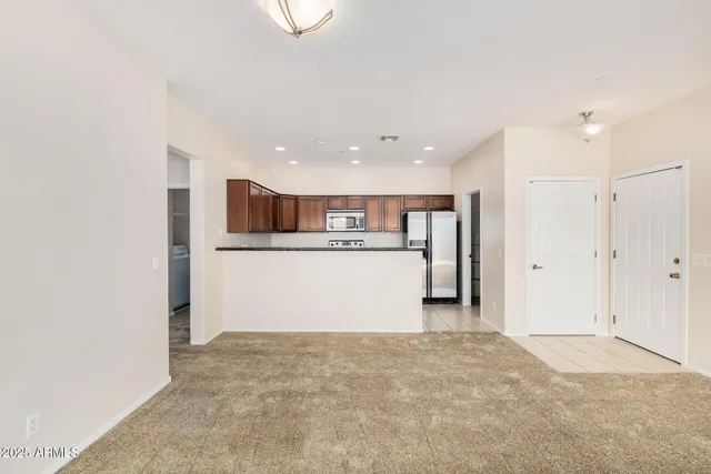 a view of a kitchen with a refrigerator wooden cabinets and a ceiling fan