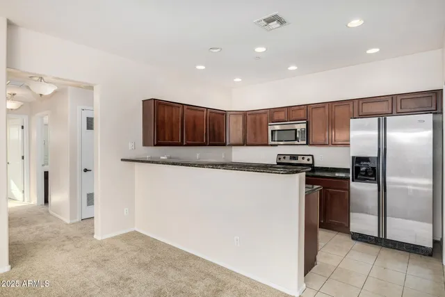 a kitchen with stainless steel appliances granite countertop a refrigerator and a stove