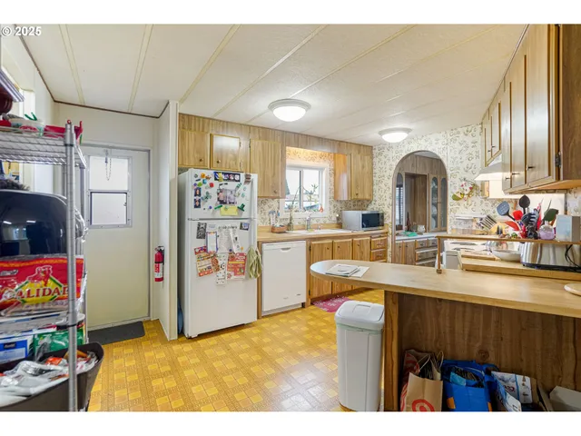 a kitchen with stainless steel appliances kitchen island granite countertop a refrigerator and a sink