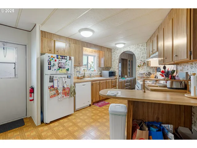 a kitchen with stainless steel appliances granite countertop a sink a refrigerator and a stove