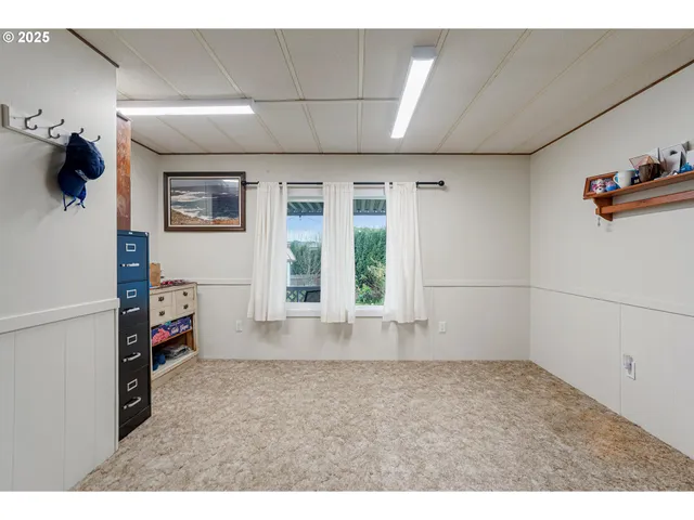 an empty room with windows and cabinet