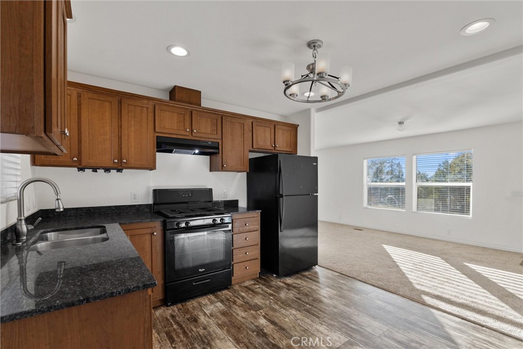 6328 Diamond Paradise, CA 95969 - Photo 9 of 31 a kitchen with granite countertop wooden floors stainless steel appliances a sink and a window