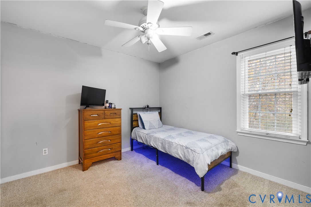 7736 Secretariat Drive Midlothian, VA 23112 - Photo 23 of 35 a bedroom with a bed and a chandelier