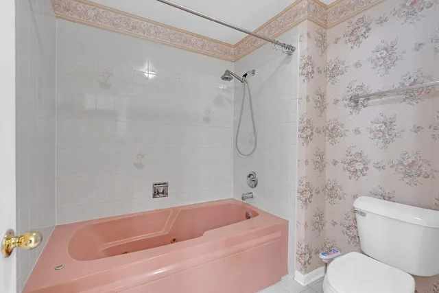 a bathroom with a shower sink vanity mirror and toilet