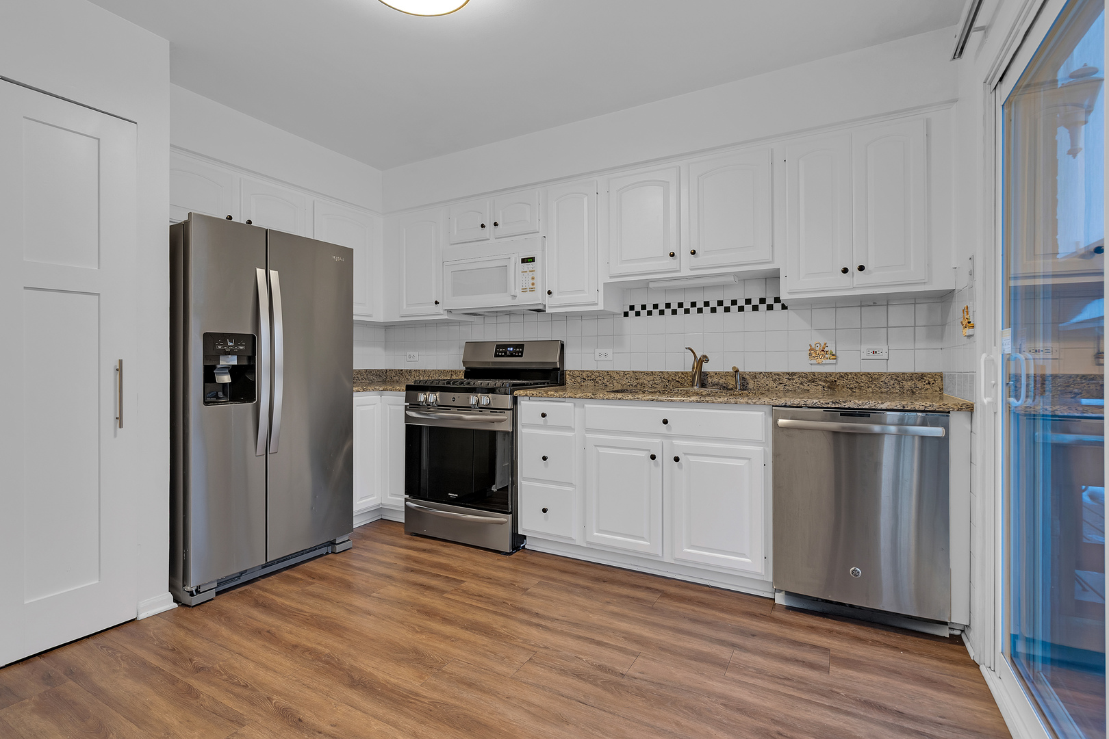 7910 Belle Rive Court, Unit 7910 Tinley Park, IL 60477 - Photo 10 of 21 a kitchen with granite countertop white cabinets and stainless steel appliances
