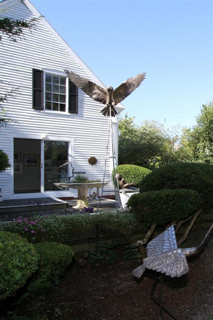 40 Main Street Wellfleet, MA 02667 - Photo 8 of 35 a front view of a house with a yard and garage