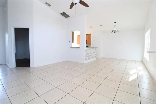 a view of a room with a ceiling fan and window