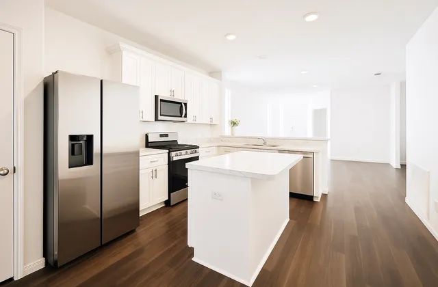 a kitchen with a refrigerator sink and cabinets