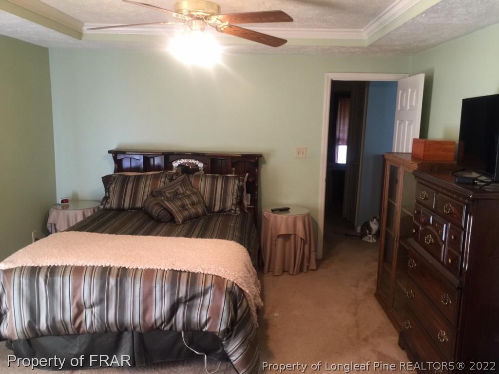 212 Overton Road Raeford, NC 28376 - Photo 14 of 19 a bedroom with a bed and a flat tv screen on the dresser