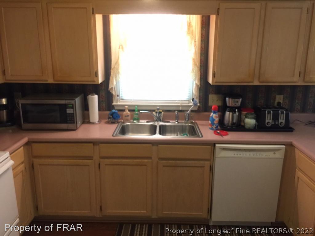 212 Overton Road Raeford, NC 28376 - Photo 8 of 19 a kitchen with stainless steel appliances granite countertop a sink and a microwave