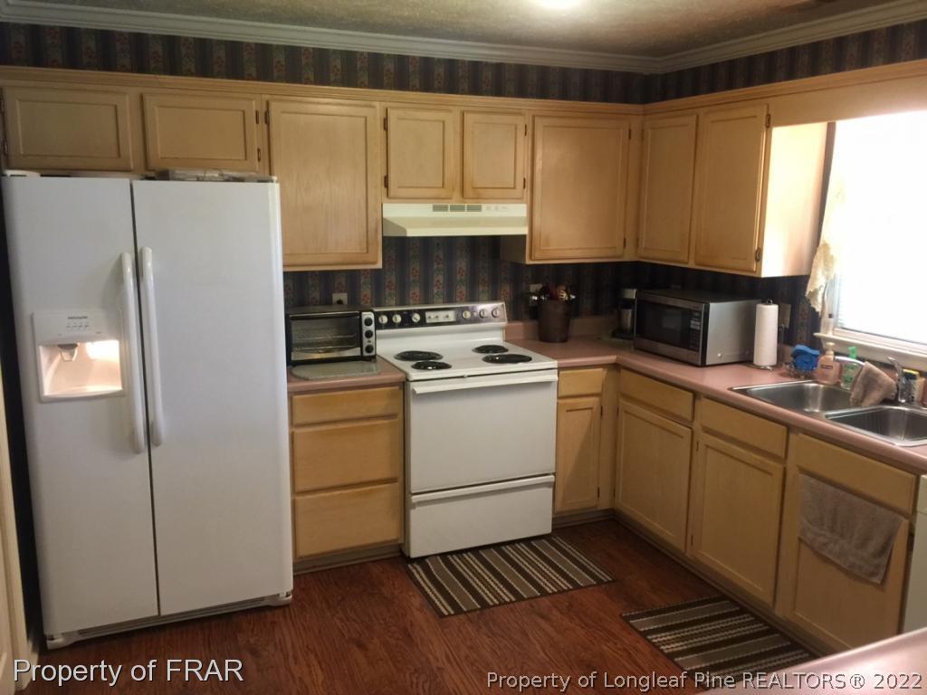 212 Overton Road Raeford, NC 28376 - Photo 9 of 19 a kitchen with a sink a stove and refrigerator