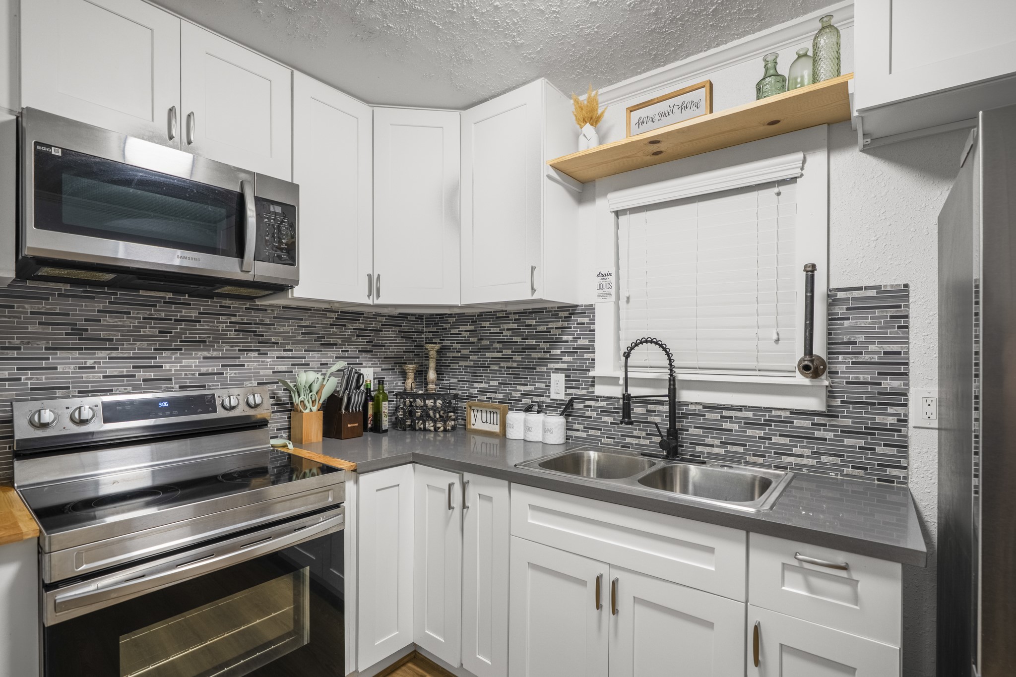 206 Murray Street Conroe, TX 77301 - Photo 25 of 38 a kitchen with stainless steel appliances a stove sink and microwave
