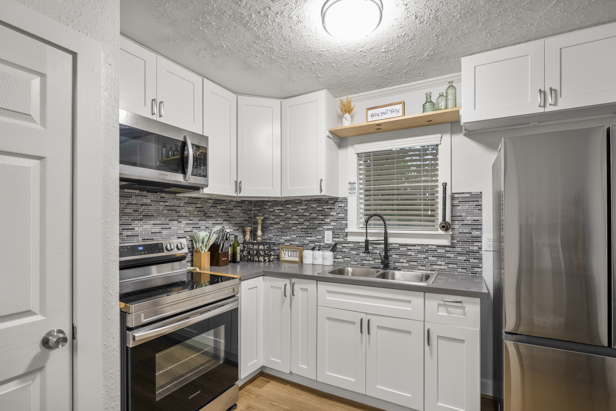 206 Murray Street Conroe, TX 77301 - Photo 30 of 38 a kitchen with granite countertop white cabinets stainless steel appliances and a sink