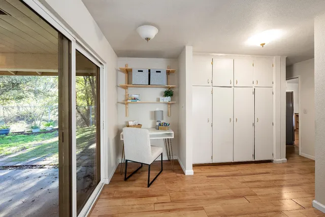 a view of a kitchen with wooden floor and a window