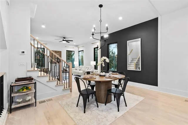 a dining room with furniture a chandelier and wooden floor