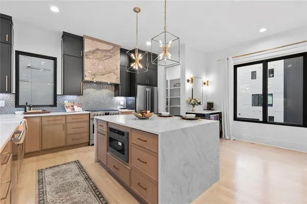 a large kitchen with kitchen island a large counter space a sink appliances and cabinets