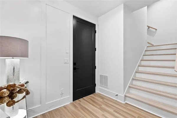 a view of a hallway with wooden floor and closet