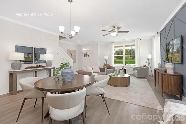 a dining room with furniture a chandelier and wooden floor